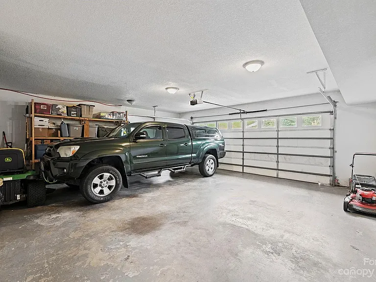Spacious garage with built-in wooden shelves along one wall.