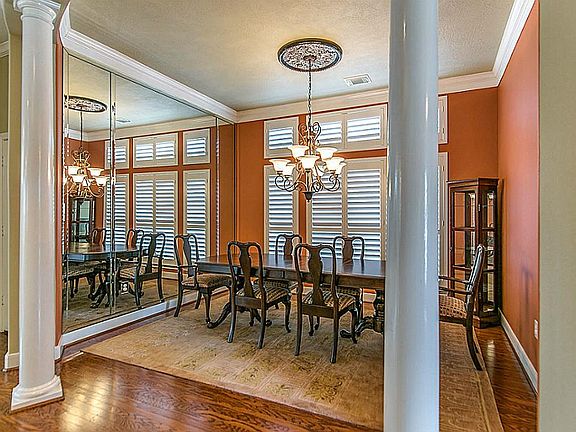 Spacious and elegant, this Formal Dining Room is complete with floor to ceiling mirrors, grand chandelier, plantation shutters, decorative columns, and room for all of your family and friends to gather around!