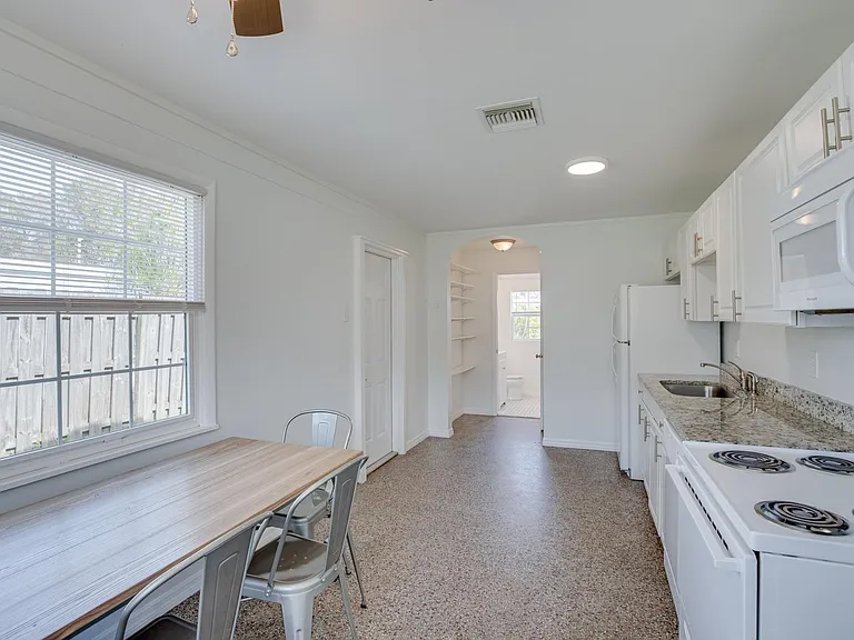 Large eat-in kitchen with granite counters, terrazzo floor, and ceiling fan. Access to 3/4 bath.