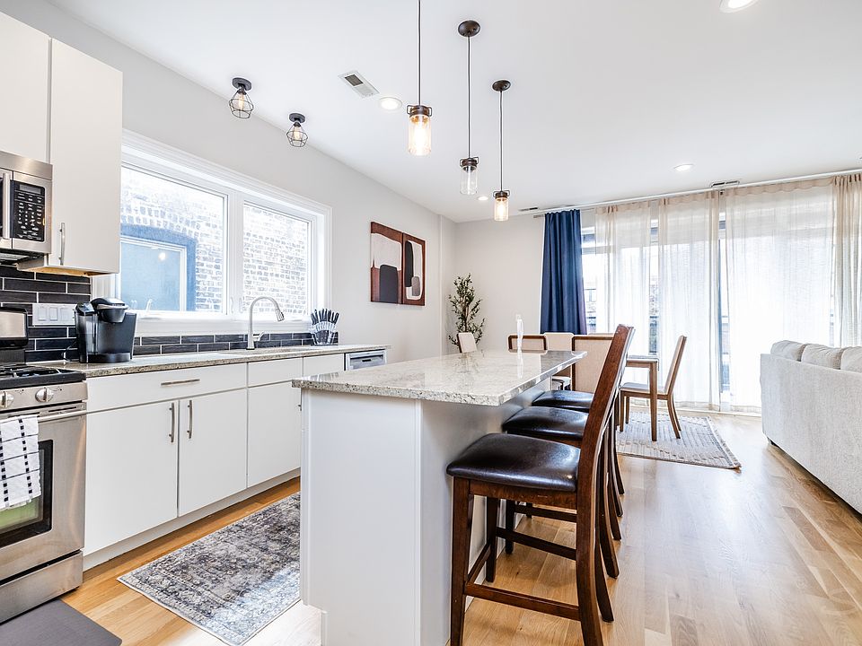 The fully equipped open-concept kitchen includes a large island and full thickness granite countertops.