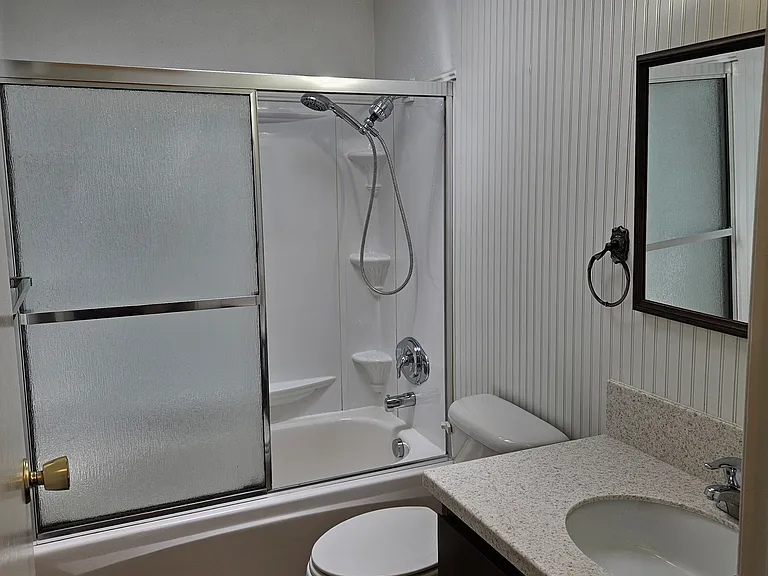 Upstairs bathroom with full tub, shower, toilet, sink and skylight