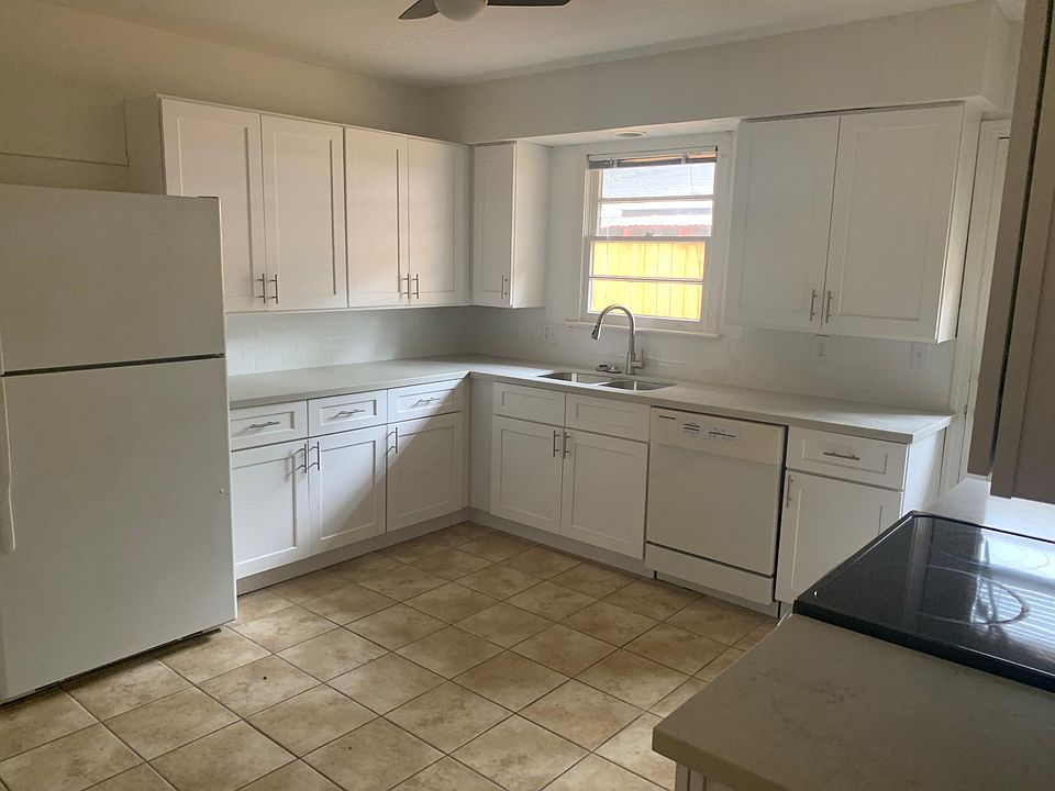 Kitchen with electric oven, microwave, dishwasher, and fridge with ice maker. Tons of cabinet space with a double sink and quartz countertops.
