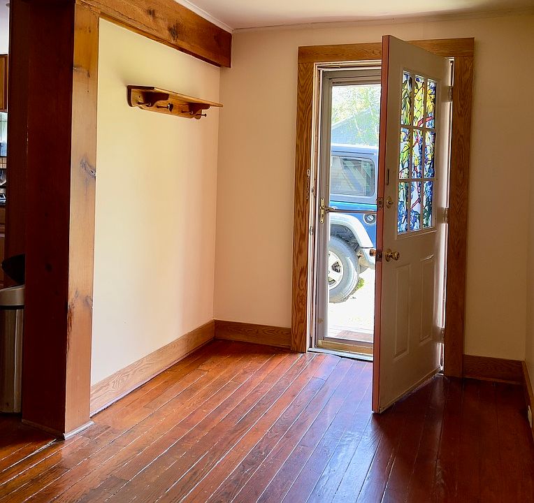 The foyer/dining room area opens to the kitchen on the left and leads to the side entrance, which is along the driveway for parking.
