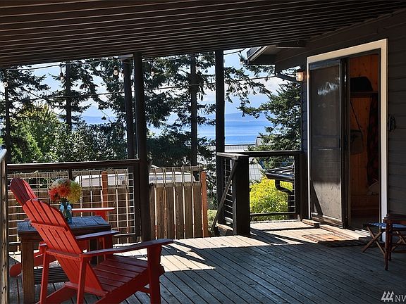 Spacious covered deck with stunning views. You will enjoy the ease of flow from indoor to outdoor living whether enjoying solo or hosting a party. Step through the glass doors....next photo....