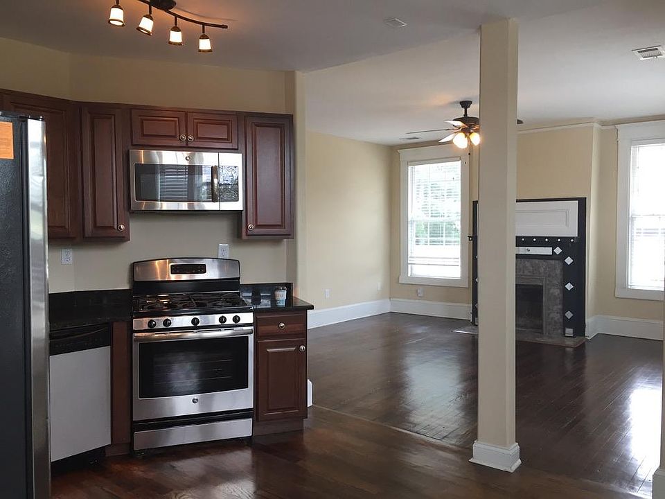 View of spacious living room from kitchen with all updated appliances