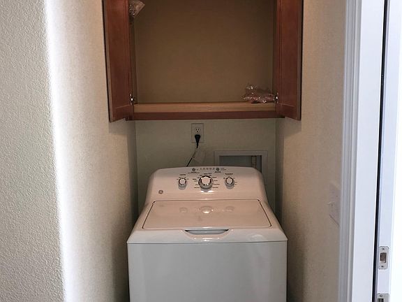 Washing machine with cabinet above