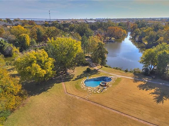 The pool and hot tub... the cabins are still hiding in the trees.  Various paths lead up and down the property. The perimeter from the lake up to the house has invisible fencing, if you have dogs. The lake wraps around this property!