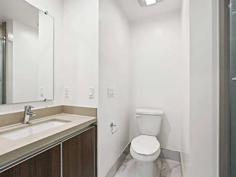 Bathroom with Walk-In Shower with Glass Door and Vanity Cabinet Storage