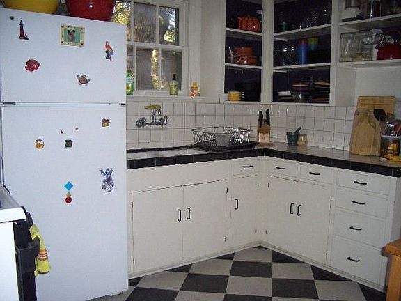 Kitchen with ceramic tile counter and backsplash, gas stove and refrigerator