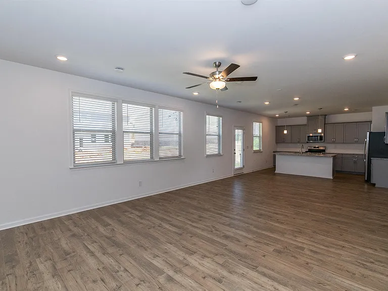 Open kitchen featuring a refrigerator, sink, and ceiling fan.