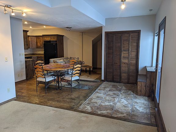 Front door on right, looking from living room toward kitchen. On the left is bathroom and bedroom, and the far door leads to laundry room.