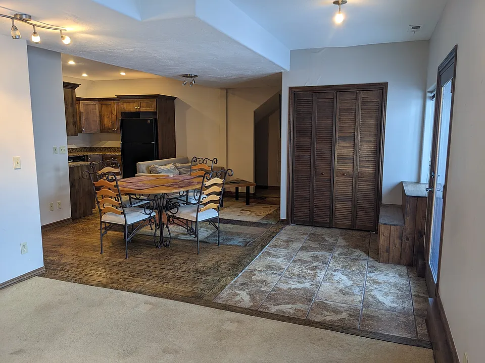 Front door on right, looking from living room toward kitchen. On the left is bathroom and bedroom, and the far door leads to laundry room.