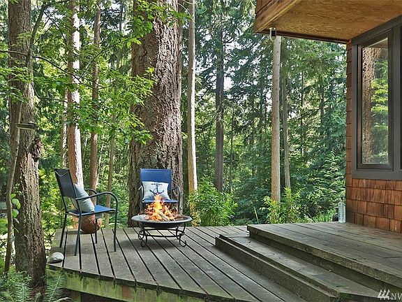 Private back deck along the southwest corner of the house.  The eastern portion of these lots border acreage creating a backdrop of forest.  Windows to the right are from the dining/living area of the home.