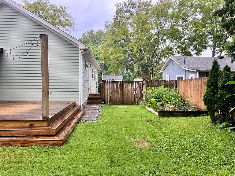 Side yard looking towards driveway. Raised garden bed