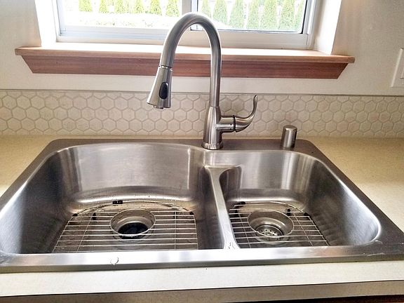 New Stainless Steel Sink with grates and garage disposal, new tile backsplash