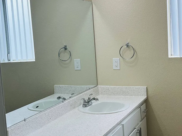 Bathroom with large vanity and window at Plaza Verde Apartments in Escondido, California.