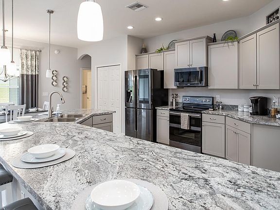 Your new gourmet kitchen has ample counter space, a walk-in pantry, and is fully open to the gatheri
