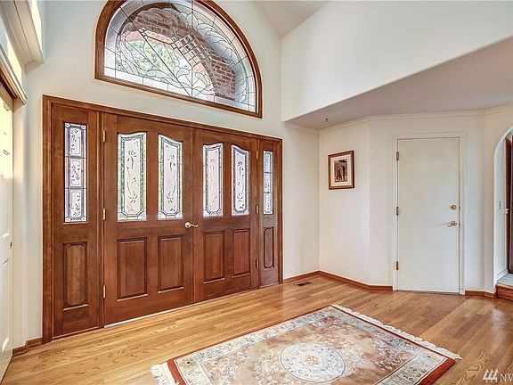 Greet your guests in the beautiful foyer with hardwood floors, custom double door adorned with stained glass and a stained glass feature window above. 