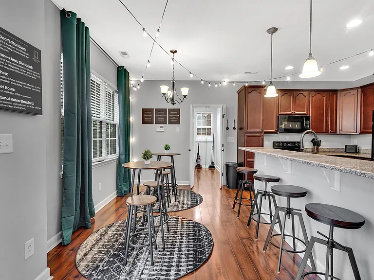 Eat-in kitchen with breakfast bar seating, granite-look counters, ample cabinetry, and adjacent dining nook.