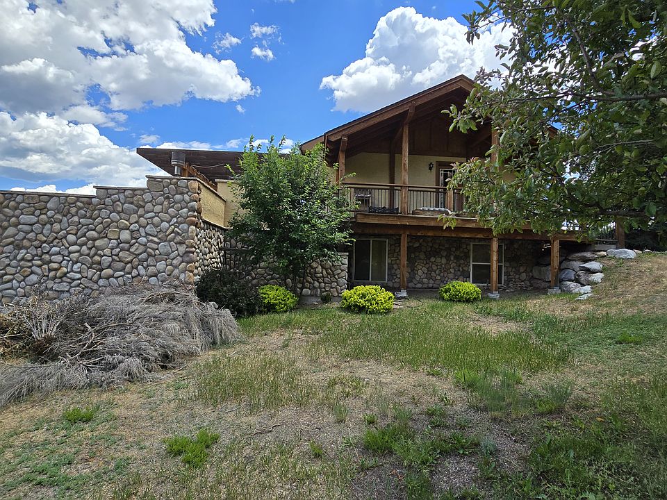 Gas fired fire pit mid level deck beyond river stone wall with huge upper deck looking over Eagle River