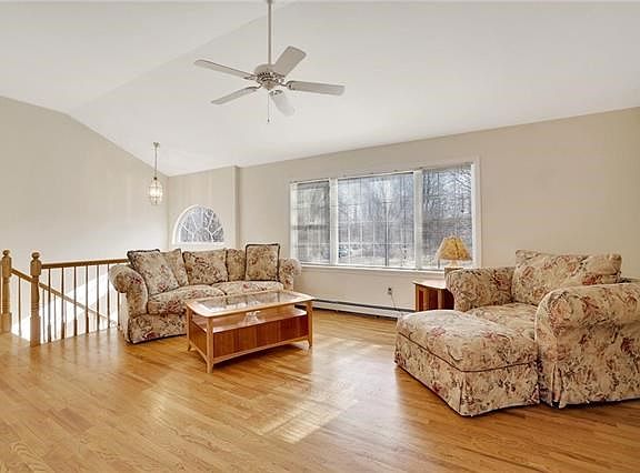 Hardwood flooring accents the large living room with cathedral ceilings.