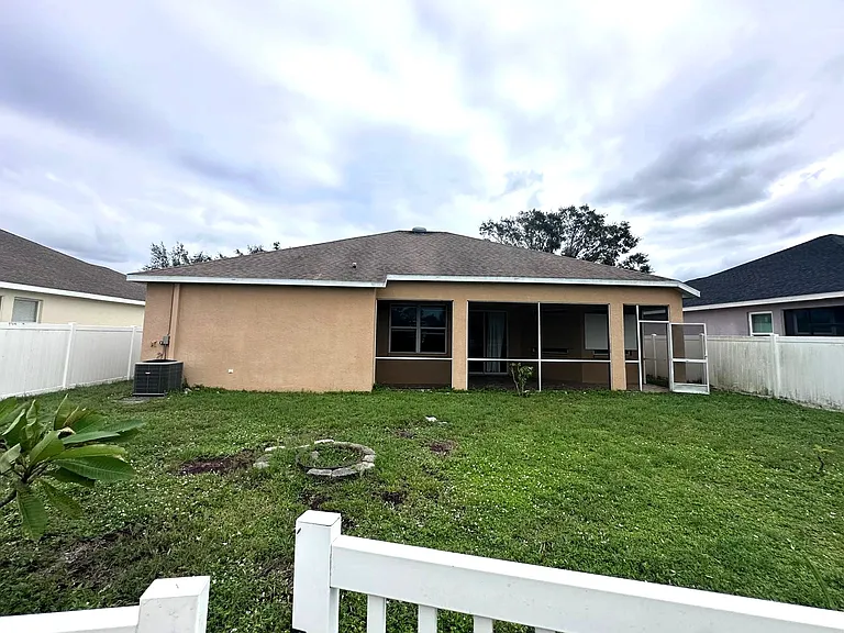 large fenced back yard with screened in Lanai