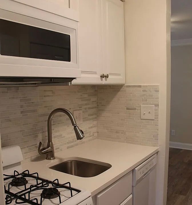 Kitchen: gas stove, oven, vent, big microwave, dishwasher, sink.