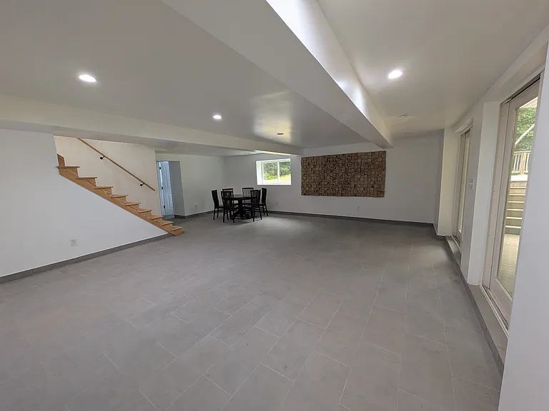 Downstairs living area with access to covered deck and pool