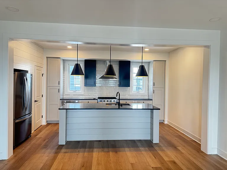 Kitchen with refrigerator, freezer, cabinetry, stainless steel appliances, and an island that can accommodate high chairs for seating