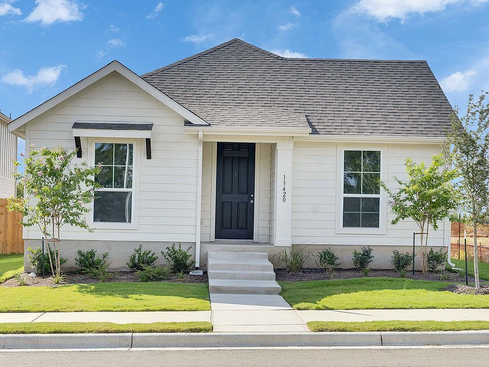 Elegant gabled roof and sleek beige siding define this Creeks Crossing residence s sophisticated cha