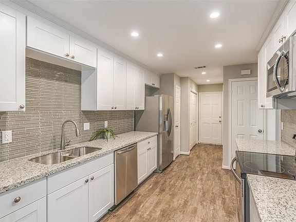 A gorgeous kitchen awaits! All white cabinets, tile work, flooring, lighting, paint and recently added stainless steel appliances updated less than 2 years ago!