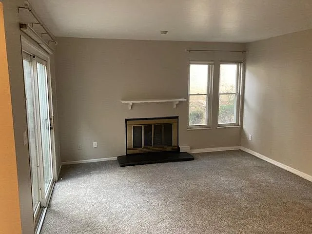 Living room area with gas fireplace leading out to private back patio.