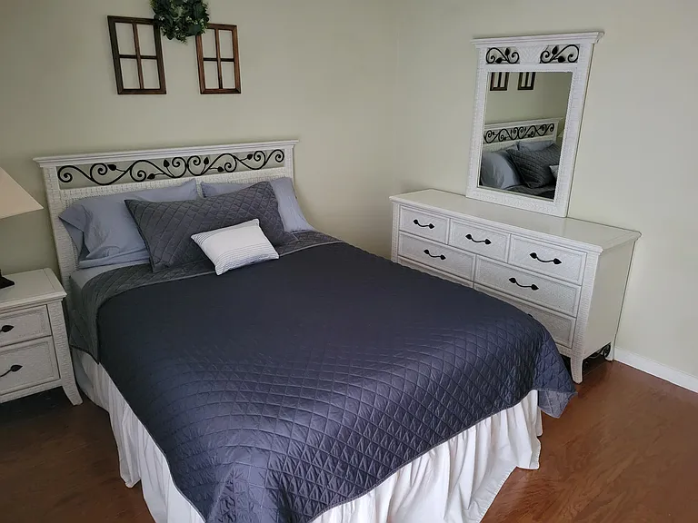 Bedroom 2 with queen size bed, night stand, closet and a chest of drawers.