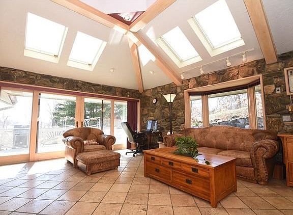 Large family room with skylights, a wood burning stove, slider to large deck for summertime entertaining.