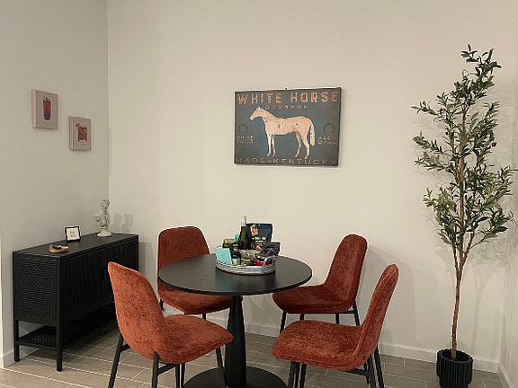 Enjoy meals at the inviting dining area, complete with a table and four comfortable chairs. A stylish side bar table provides extra space for serving drinks, appetizers, or displaying decorative items.