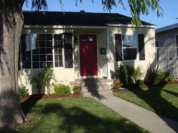 front yard, from left view, with large, mature tree (trunk) in picture