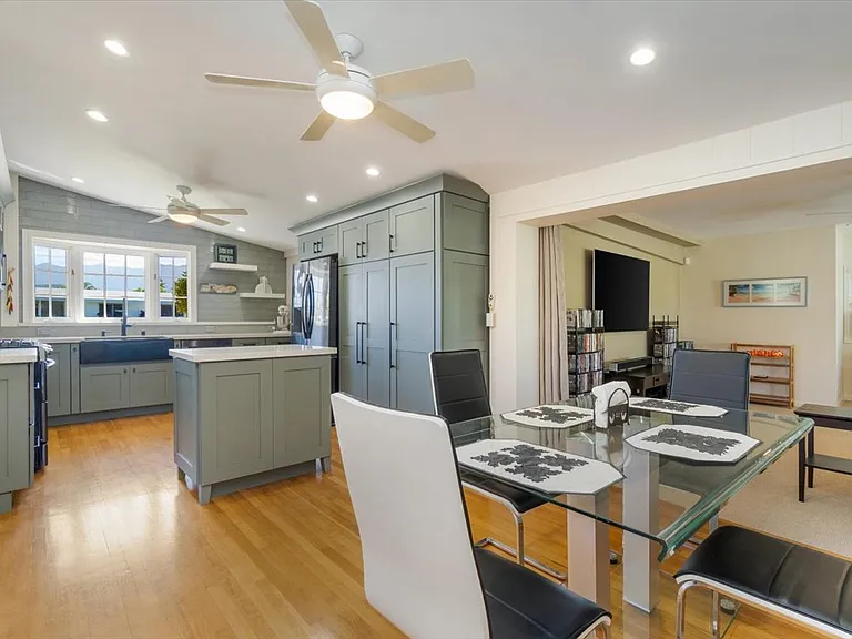 View of the kitchen from the dining area in the forefront. Notice the access to the family room/theatre to the right. Access to the formal living room is to the left outside of the picture.