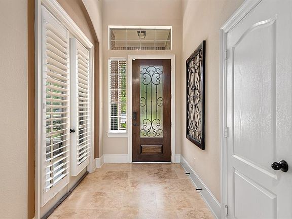 The view back toward the front door highlights the gorgeous flooring and high ceilings. The study with plantation shutters is just to the right once you walk through the front door.