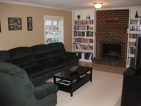 Roomy family room w/ built-in bookcases and a brick fireplace