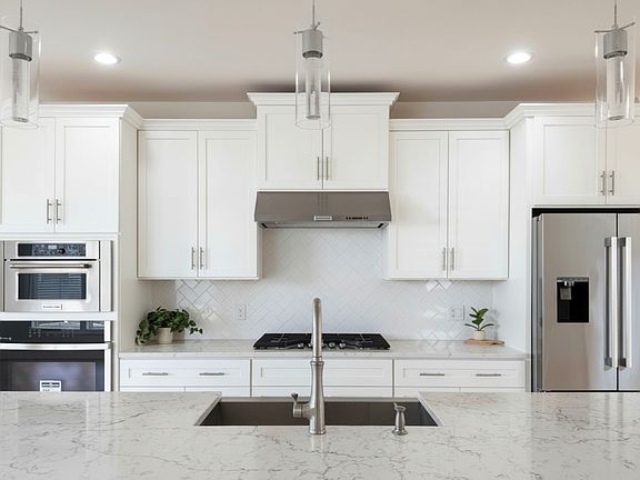 Pristine and modern kitchen with sleek finishes and oversized quartz island.