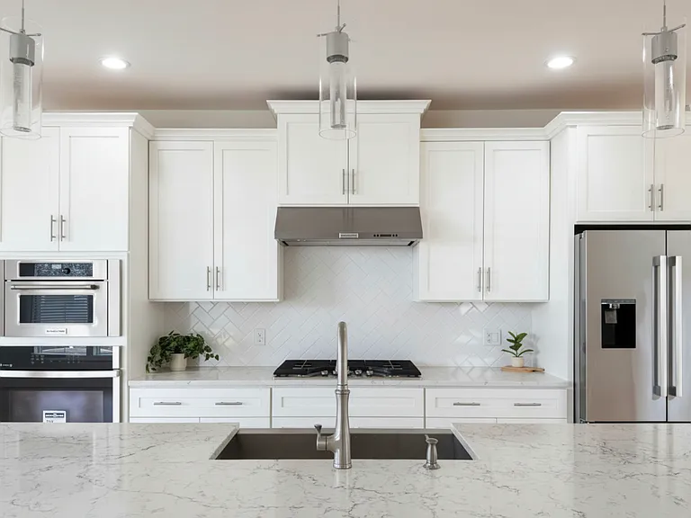 Pristine and modern kitchen with sleek finishes and oversized quartz island.