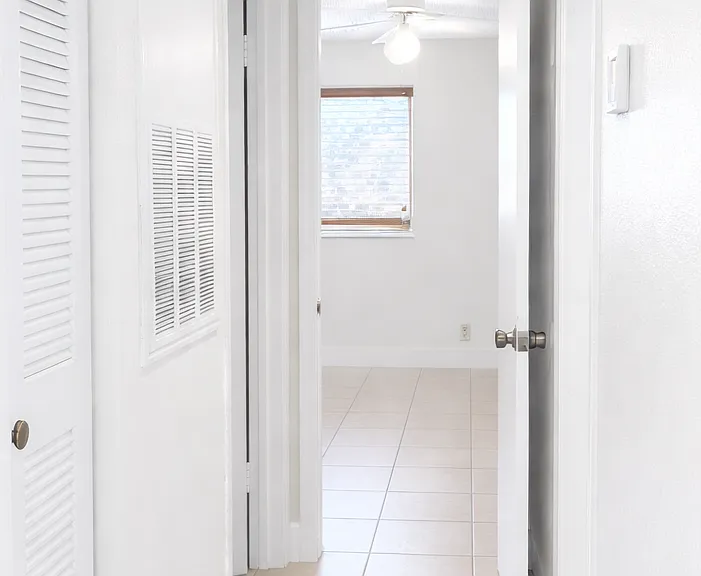 Hallway to bedroom 1 and bathroom. Left door to storage room