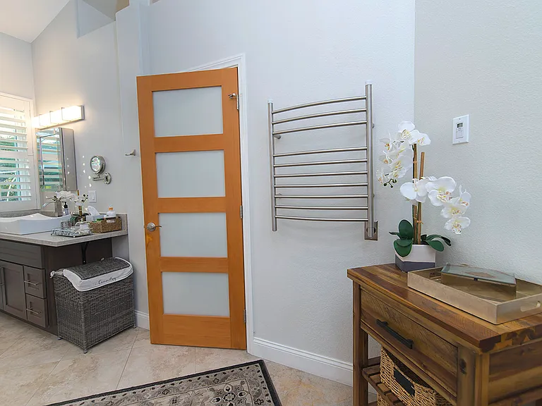 Direct access from the primary bedroom to the ensuite bath with step-in shower and facilities. On the wall there is a towel warmer.