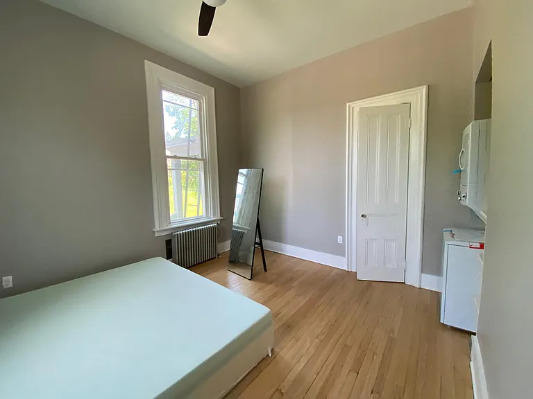 view of bedroom with king bed, ceiling fan, washer and dryer not included. There is a coin op washer/dryer in basement