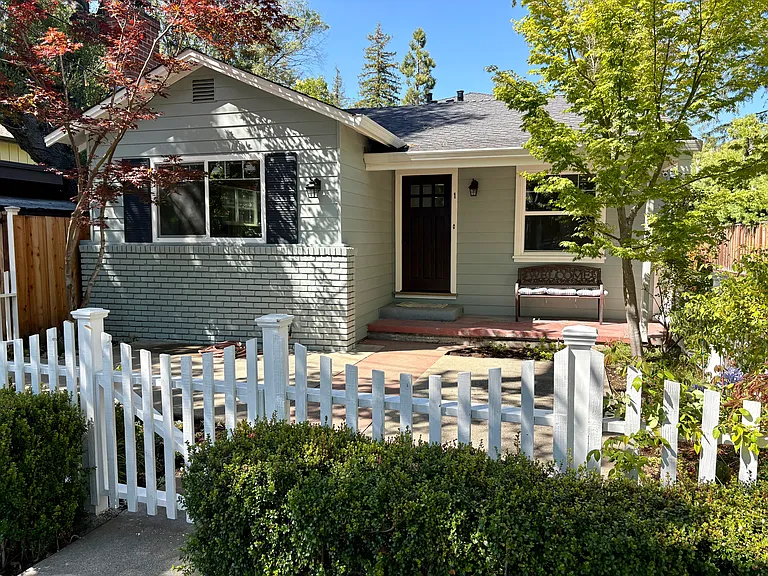 Sunny front yard with charming picket fence.