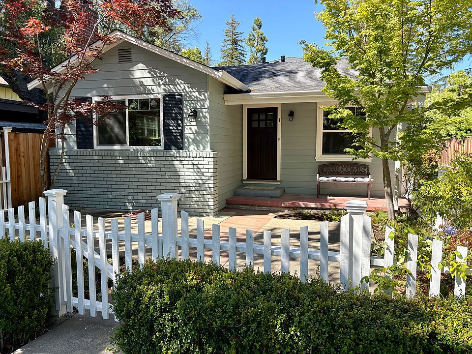 Sunny front yard with charming picket fence.
