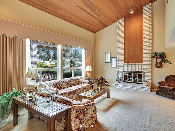 Two story, vaulted living room with wood burning fireplace and large windows for great natural light!>
