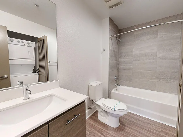 Apartment bathroom with wood-style flooring.