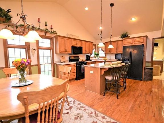 Huge eat-in kitchen showcasing the beautiful hardwood floors, expansive cabinetry with ample counter space, kitchen island, 4x7 