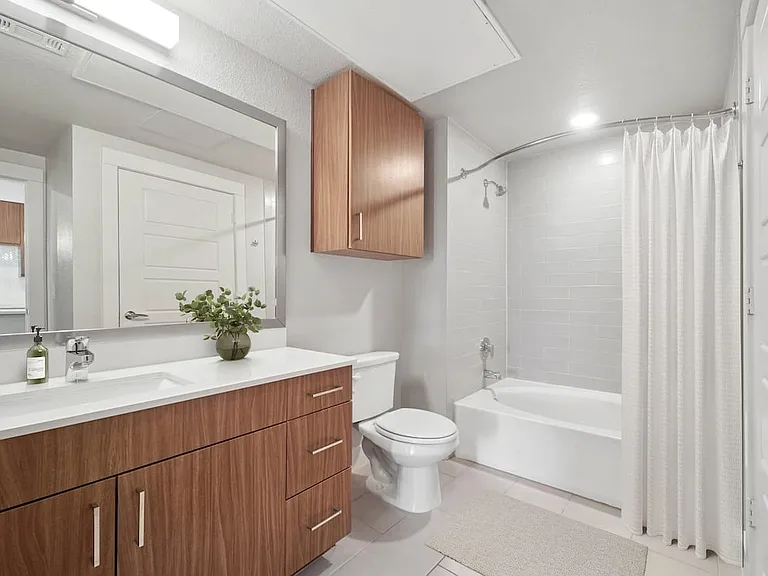 Finish Package I bath with white quartz countertops and dark cabinetry